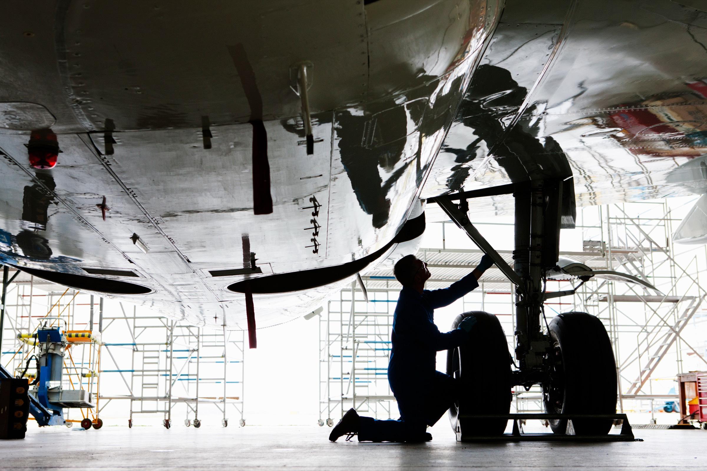 Two executives shaking hands before an aircraft